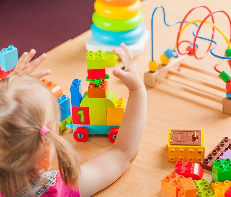 Toddler playing with colorful building blocks