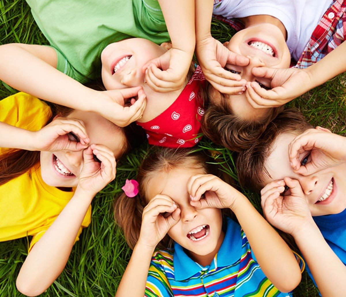 Group of children laughing and playing together outdoors